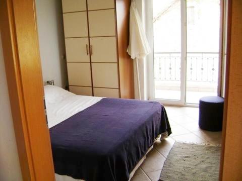 ein Schlafzimmer mit einem Bett und einem großen Fenster in der Unterkunft Apartment in Podgora with sea view, terrace, air conditioning, WiFi 3812-2 in Podgora