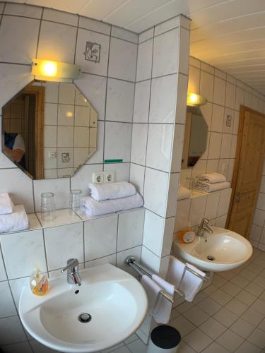 a white bathroom with a sink and a mirror at Zimmervermietung Ziegltrum in Wolfersdorf