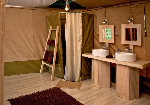 a bathroom with two sinks and a ladder in a tent at Kicheche Valley Camp in Naboisho