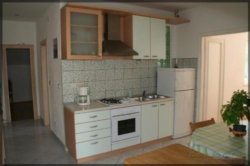 eine Küche mit einem Herd und einem weißen Kühlschrank in der Unterkunft Apartment in Bol with sea view, terrace, air conditioning, WiFi 3739-1 in Bol