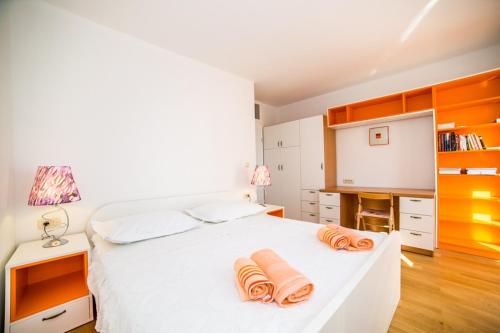 Un dormitorio con una cama blanca con toallas naranjas. en Apartment in Bol with sea view, terrace, air conditioning, WiFi 3739-3 en Bol