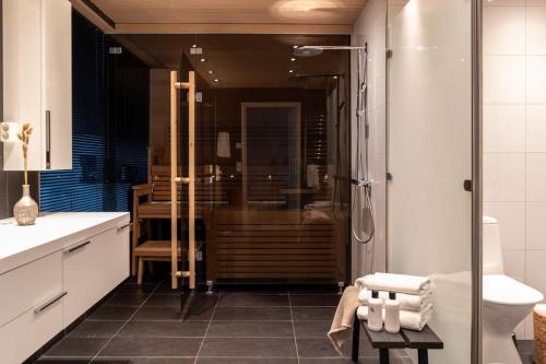 y baño con ducha, aseo y lavamanos. en Spacious and central apartment with private sauna, en Helsinki