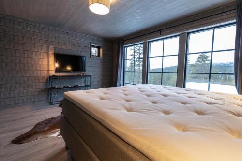 a bedroom with a large bed and a tv at Sälen Mountain Lodge in Sälen
