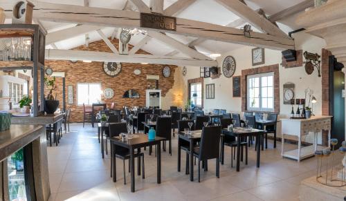 un restaurant avec des tables et des chaises dans une salle dans l'établissement L'Horloge Gourmande, à Donzère