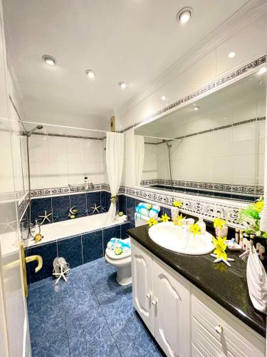 a bathroom with a sink and a toilet and a mirror at EmyCanarias Primera Línea De Playa in Arinaga