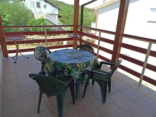 a table and chairs on a balcony with a table and chairs at Apartments Kornati in Ždrelac
