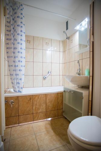 a bathroom with a shower and a toilet and a sink at Otthon-Laksz apartman in Nyíregyháza