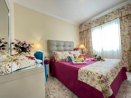a bedroom with a purple bed with a window at EmyCanarias Primera Línea De Playa in Arinaga