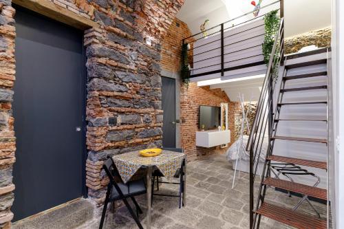 a room with a table and a brick wall at Antico Basolato House in Catania