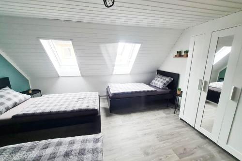 a attic bedroom with two beds and a window at Work & Stay apartment Vohburg near Ingolstadt in Vohburg an der Donau