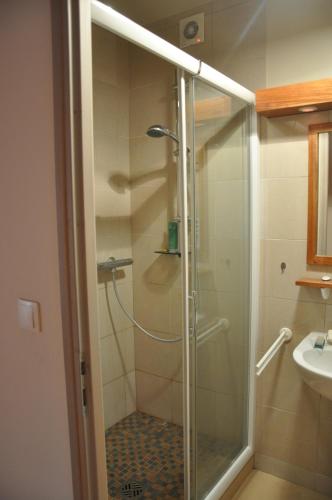 a shower with a glass door in a bathroom at La Ferme de Vrilly in Reims