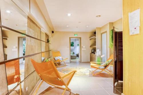 a living room with chairs and a staircase at Kyriad Restaurant Centre SPA Vichy in Vichy