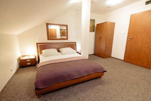 a bedroom with a bed and a mirror on the wall at Orion Hotel Parczew in Parczew