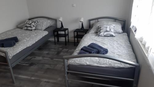 Dos camas en un dormitorio con toallas azules. en 2 Zimmer Appartements in Heroldsatt, en Heroldstatt