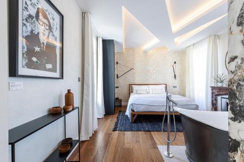 a bathroom with a tub and a bed in a room at Le Dortoir Boutique Suites in Nice
