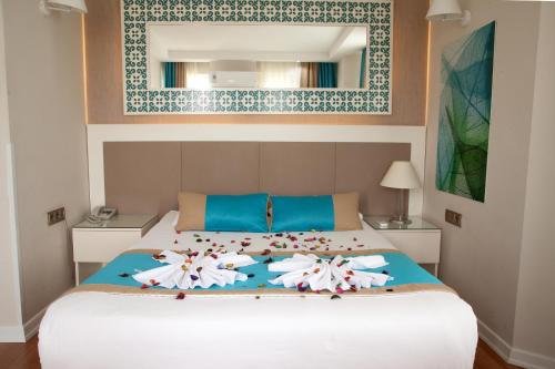 a bedroom with a bed with flowers on it at Nasa Flora Hotel in Antalya