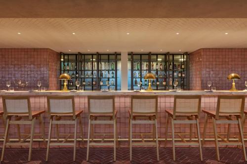 a bar in a restaurant with stools at One Hundred Shoreditch in London