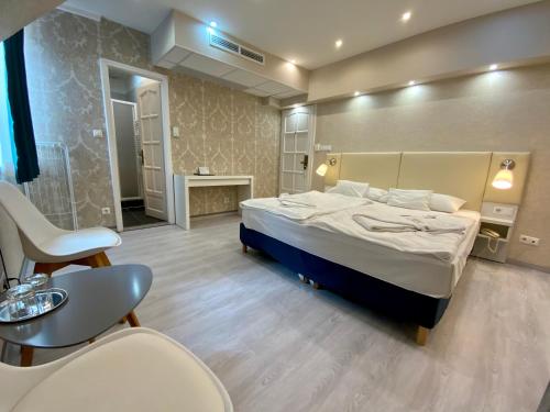 a bedroom with a bed and a table and chairs at Bástya Konferencia és Wellness Hotel in Miskolctapolca