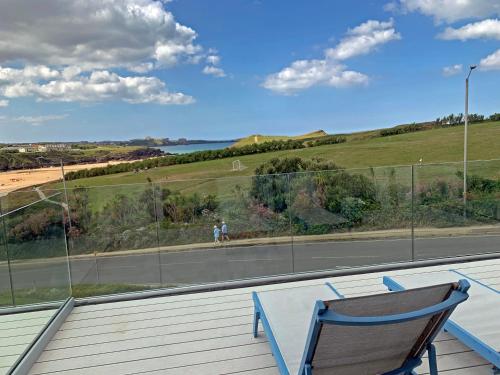 a table and a chair sitting on a porch at Porth Beach Hotel in Newquay
