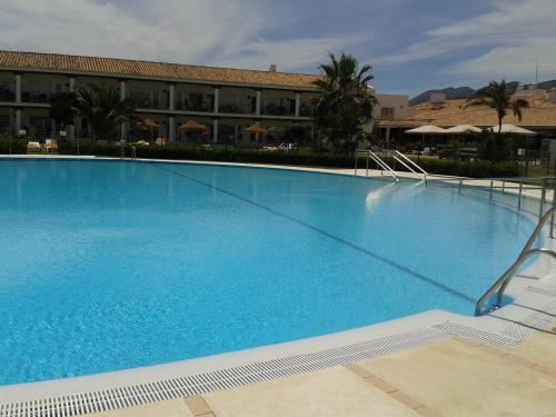 a large blue swimming pool in front of a building at Parador de Málaga Golf in Málaga