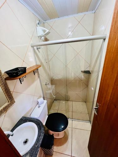 a small bathroom with a toilet and a sink at Pousada Rosa Center in Praia do Rosa