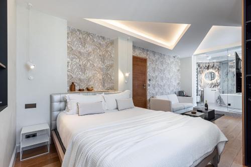 a bedroom with a large white bed and a bathroom at Le Dortoir Boutique Suites in Nice