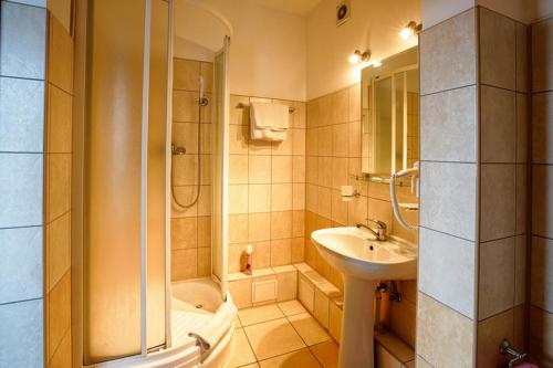カリーニングラードにあるFriedrichshoff Hotelのバスルーム(シャワー、シンク、バスタブ付)