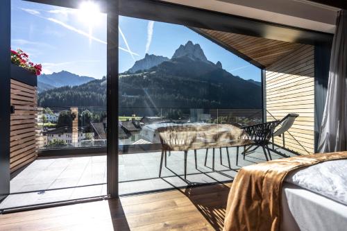 a bedroom with a balcony with a view of mountains at Ladinia Dolomites View - Adults Only in Pozza di Fassa
