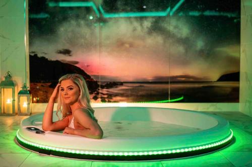 a woman is sitting in a bath tub at Ballyliffin TownHouse Boutique Hotel in Ballyliffin