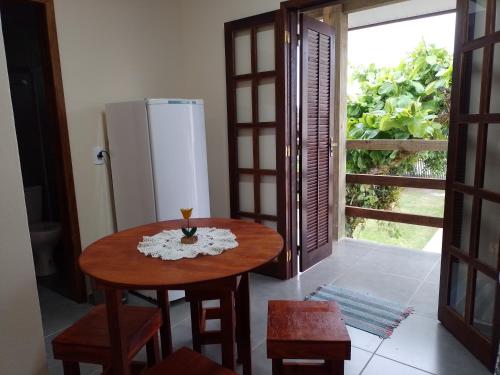 eine Küche mit einem Holztisch und einem Kühlschrank in der Unterkunft Residencial Lumar in Itapoa