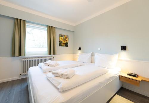 een hotelkamer met twee bedden met handdoeken erop bij Appartement Beka 15 in Westerland