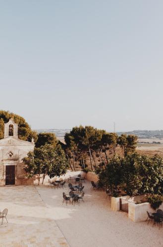 a group of tables and chairs in front of a building at Masseria Fontana di Vite in Matera