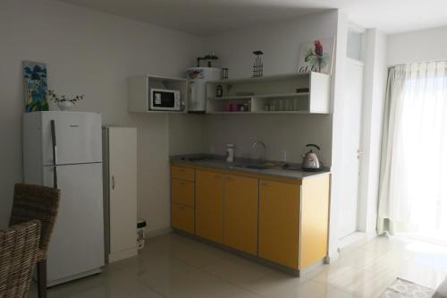 a kitchen with a white refrigerator and a sink at Moderno y cómodo monoambiente en San Juan capital in San Juan