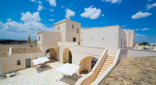 a large white building with stairs and a blue sky at Masseria Fontana di Vite in Matera