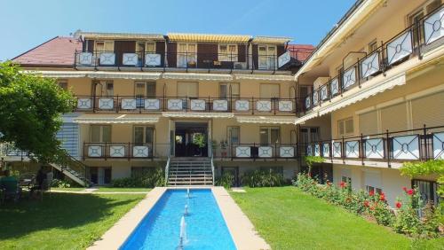 a building with a swimming pool in front of it at Hotel Hofmann Zur Mühle in Bad Krozingen