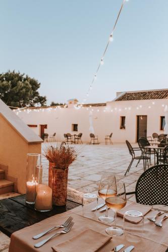 a table with glasses and candles on a patio at Masseria Fontana di Vite in Matera