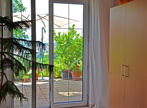 an open glass door with a view of a garden at Anna Apartment in Budaörs