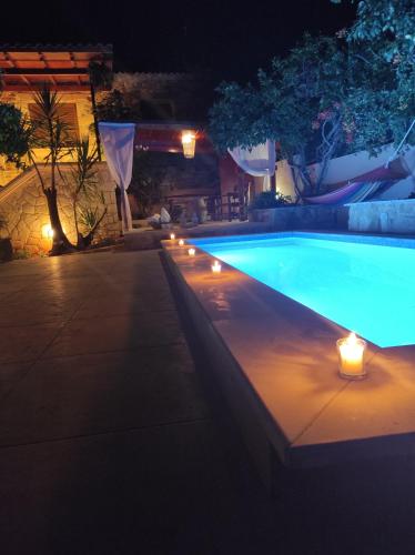 a swimming pool at night with candles in the water at Villa Anthemida Chania in Ayiá
