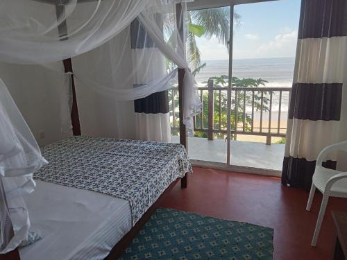 a bedroom with a bed and a view of the ocean at Himana Beach Rest in Matara