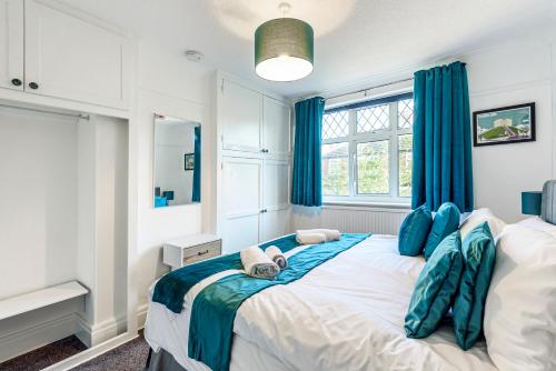 a bedroom with a large bed with blue curtains at Bishy Road Hideaway near York Racecourse in York