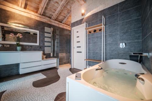 een badkamer met een bad en een wastafel bij Chalet Ancolie in Tignes