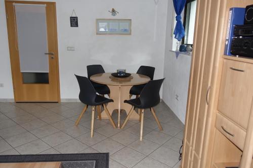 a table and chairs in a room with a kitchen at Ferienwohnung-Zoe in Sankt Wendel