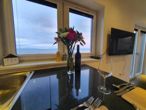a table with a vase of flowers and a wine glass at 22 Waters Edge Banff in Banff