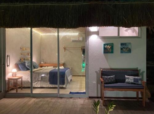 a bedroom with a bed in a room with glass doors at Club Manguaba Beira Mar in Japaratinga