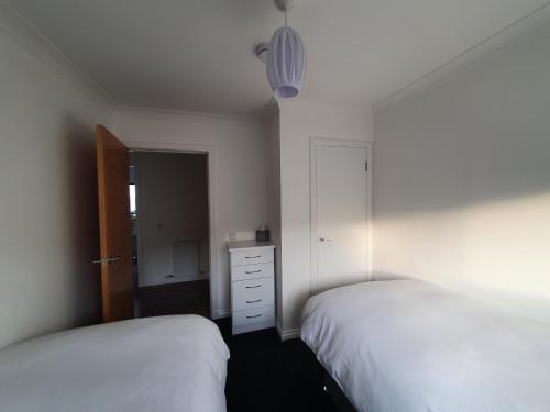 a bedroom with two beds and a dresser in it at 22 Waters Edge Banff in Banff