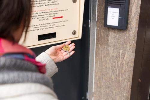 a woman is holding a key to a machine at Königshof Bed and Breakfast in Königstein im Taunus