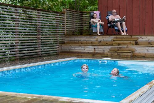 two children swimming in a swimming pool at Lyrsta R B&B in Lyrestad