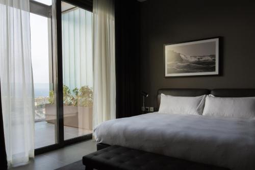 a bedroom with a bed and a large window at InterContinental Malta by IHG in St Julian's