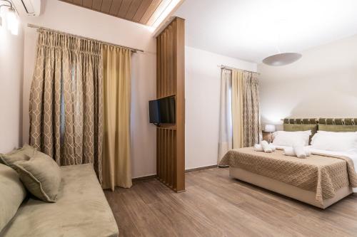 a bedroom with a bed and a flat screen tv at LYDIA suites and rooms in Litochoro