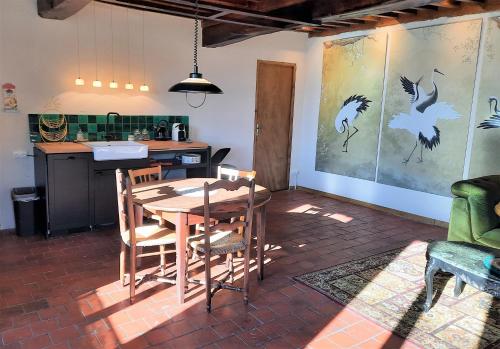 - une cuisine et une salle à manger avec une table et des chaises dans l'établissement Gite de l'étang Rangère, à Villapourçon